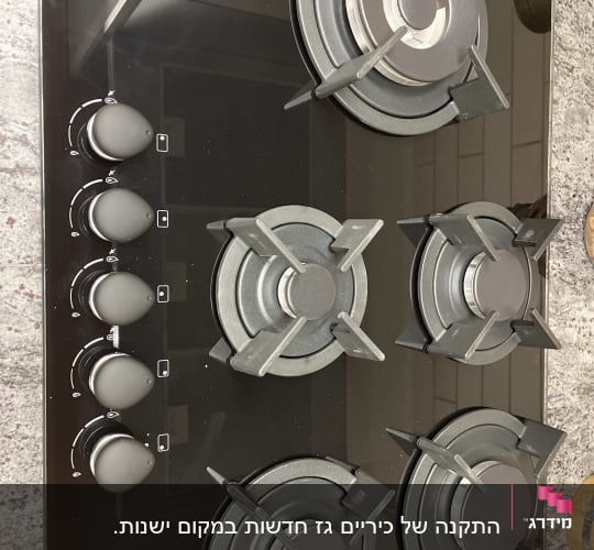 כיריים גז שחורות עם חמישה מבערים וכפתורי שליטה